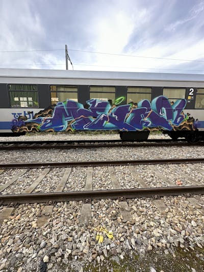 Violet and Cyan and Colorful Stylewriting by Menni96. This Graffiti is located in Switzerland and was created in 2023. This Graffiti can be described as Stylewriting, Trains and Freights.