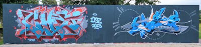 Light Blue and Red Stylewriting by CHE and Jase One. This Graffiti is located in Heerlen, Netherlands and was created in 2023. This Graffiti can be described as Stylewriting, Characters and Wall of Fame.