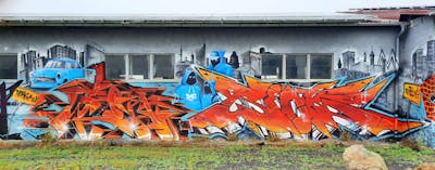 Orange and Light Blue and Grey Stylewriting by Wok and Riots. This Graffiti is located in Oschatz, Germany and was created in 2023. This Graffiti can be described as Stylewriting and Characters.
