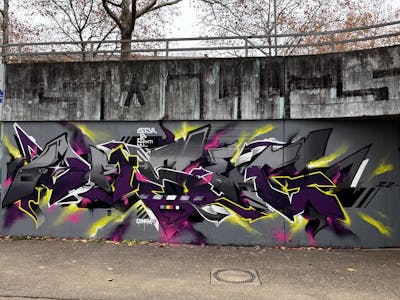 Grey and Violet and Yellow Stylewriting by omseg. This Graffiti is located in Freiburg, Germany and was created in 2023.