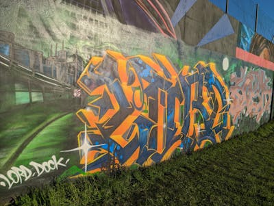 Orange and Blue and Green Stylewriting by LORD, Dock and Kosh. This Graffiti is located in Caen, France and was created in 2023. This Graffiti can be described as Stylewriting and Wall of Fame.