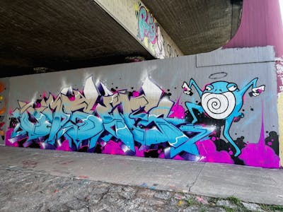Light Blue and Violet and Grey Stylewriting by omseg. This Graffiti is located in Freiburg, Germany and was created in 2023. This Graffiti can be described as Stylewriting, Characters and Wall of Fame.