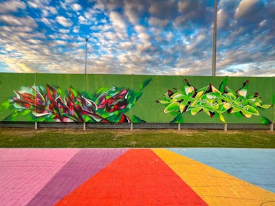 Colorful and Light Green Atmosphere by Heny and SNUZ. This Graffiti is located in lublin, Poland and was created in 2023. This Graffiti can be described as Atmosphere and Stylewriting.