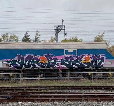 Violet and White and Black Trains by ACROS and aeon. This Graffiti is located in London, United Kingdom and was created in 2022. This Graffiti can be described as Trains, Stylewriting and Freights.