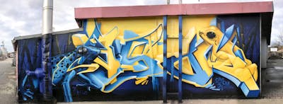 Yellow and Blue Stylewriting by casom and 7hells. This Graffiti is located in Radebeul, Germany and was created in 2021. This Graffiti can be described as Stylewriting, Characters, 3D and Murals.