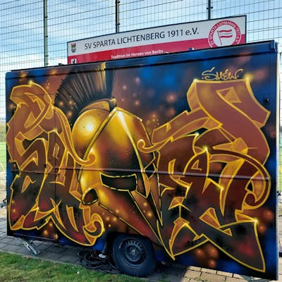 Brown and Orange Stylewriting by Shew, the Buddys and Büro21. This Graffiti is located in Germany and was created in 2022. This Graffiti can be described as Stylewriting, Cars and Characters.