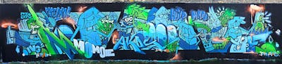 Light Blue and Light Green Stylewriting by Hülpman, OST, NBA, PÜTK, STC, TMF, Momoe, Papelapab, OCR, IVG and 3AM. This Graffiti is located in Köln, Germany and was created in 2024. This Graffiti can be described as Stylewriting, Characters, Murals and Streetart.