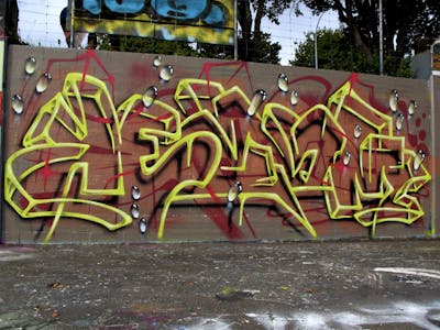 Yellow and Red Stylewriting by Kezam. This Graffiti is located in Auckland, New Zealand and was created in 2022. This Graffiti can be described as Stylewriting, 3D and Wall of Fame.