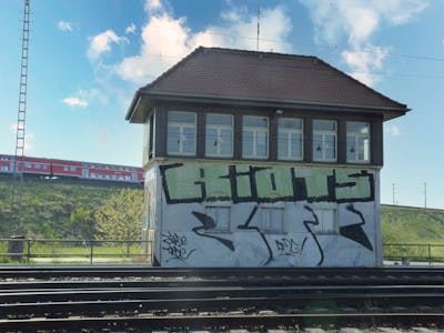 Chrome and Light Green Roll Up by Riots and Boc. This Graffiti is located in Leipzig, Germany and was created in 2010. This Graffiti can be described as Roll Up and Line Bombing.