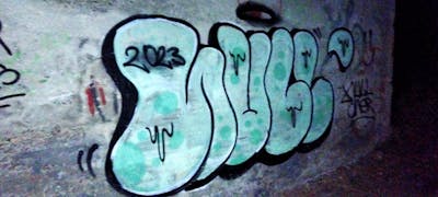Cyan and Black Throw Up by NULL. This Graffiti is located in Sândominic, Romania and was created in 2023. This Graffiti can be described as Throw Up and Stylewriting.