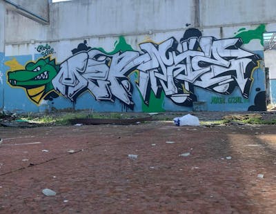 Green and White Stylewriting by Merlin and Gizmo. This Graffiti is located in Katerini, Greece and was created in 2023. This Graffiti can be described as Stylewriting, Characters and Abandoned.