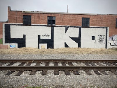 Black and Beige Roll Up by Tko Crew. This Graffiti is located in Tulsa, United States and was created in 2024. This Graffiti can be described as Roll Up and Line Bombing.