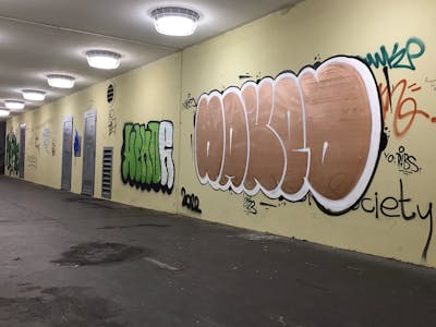 White and Gold Throw Up by Naked. This Graffiti is located in Budapest, Hungary and was created in 2023. This Graffiti can be described as Throw Up and Street Bombing.