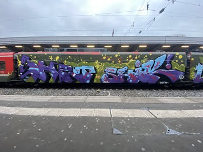 Violet and Green and Light Blue Stylewriting by shik and SHET. This Graffiti is located in ESSEN RUHRPOTT, Germany and was created in 2023. This Graffiti can be described as Stylewriting, Trains and Wholecars.