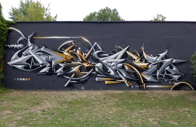 Grey and Gold Stylewriting by Rays and Nektar. This Graffiti is located in Leipzig, Germany and was created in 2019.