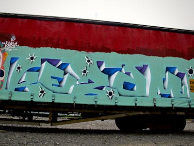 Cyan and Blue Stylewriting by Kezam. This Graffiti is located in Auckland, New Zealand and was created in 2023. This Graffiti can be described as Stylewriting, 3D, Trains and Freights.