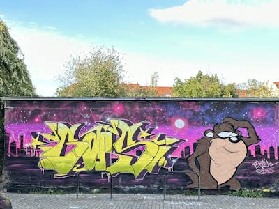 Yellow and Violet and Brown Stylewriting by Gaps and BrainTV. This Graffiti is located in Leipzig, Germany and was created in 2023. This Graffiti can be described as Stylewriting, Characters and Wall of Fame.