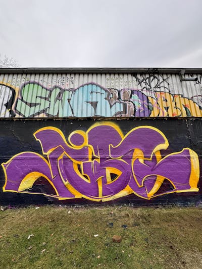 Violet and Yellow Stylewriting by Jibo and MDS. This Graffiti is located in Düsseldorf, Germany and was created in 2023. This Graffiti can be described as Stylewriting and Wall of Fame.