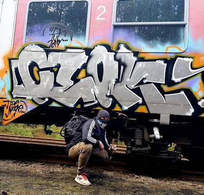 Chrome and Orange and Black Trains by CLOK THE NATURE. This Graffiti is located in Rostock, Germany and was created in 2017. This Graffiti can be described as Trains, Stylewriting and Atmosphere.