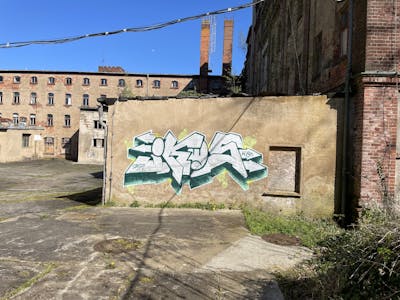 Chrome and Green Stylewriting by IKOS. This Graffiti is located in Germany and was created in 2023. This Graffiti can be described as Stylewriting and Abandoned.