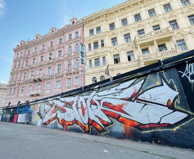 Chrome and Orange Stylewriting by Riots. This Graffiti is located in Prague, Czech Republic and was created in 2022. This Graffiti can be described as Stylewriting and Wall of Fame.