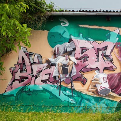 Beige and Light Green and Coralle Murals by Biest. This Graffiti is located in Radebeul, Germany and was created in 2022. This Graffiti can be described as Murals, Special, Characters and Stylewriting.
