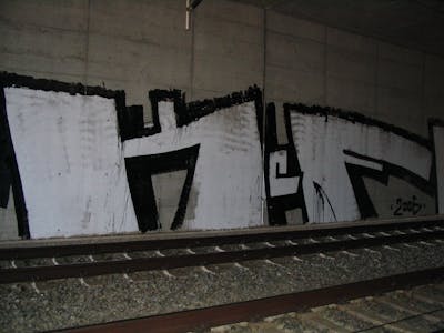 White and Black Stylewriting by urine and KCF. This Graffiti is located in Bitterfeld, Germany and was created in 2006. This Graffiti can be described as Stylewriting, Line Bombing and Roll Up.
