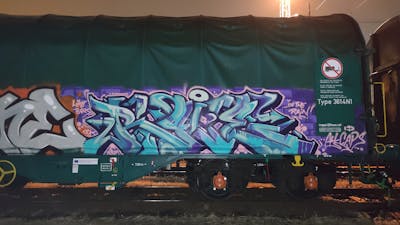 Cyan and Violet Stylewriting by Angel, DCK, Rave and ALL CAPS COLLECTIVE. This Graffiti is located in Hungary and was created in 2020. This Graffiti can be described as Stylewriting, Trains and Freights.