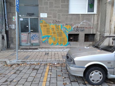 Yellow and Cyan Throw Up by 7AM. This Graffiti is located in Novi Sad, Serbia and was created in 2023. This Graffiti can be described as Throw Up and Street Bombing.