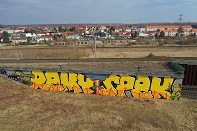 Yellow and Colorful Stylewriting by Remy and Spek. This Graffiti is located in Leipzig, Germany and was created in 2022. This Graffiti can be described as Stylewriting, Murals, Street Bombing, Characters and Line Bombing.