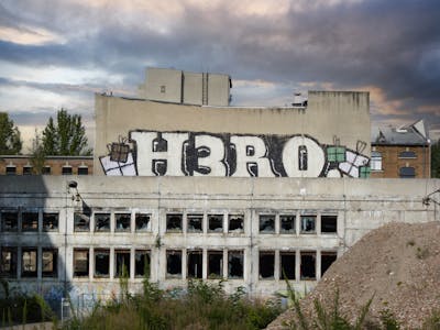Black and Grey Roll Up by Riots and Hero. This Graffiti is located in Leipzig, Germany and was created in 2010. This Graffiti can be described as Roll Up, Abandoned and Street Bombing.