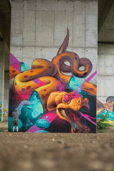 Colorful and Orange Characters by Fat Heat. This Graffiti is located in Budapest, Hungary and was created in 2021. This Graffiti can be described as Characters, Streetart, Murals and Atmosphere.