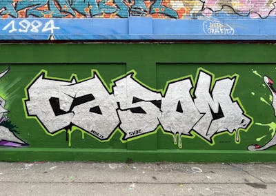 Green and Chrome and Black Stylewriting by casom. This Graffiti is located in München, Germany and was created in 2023. This Graffiti can be described as Stylewriting and Wall of Fame.