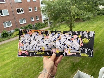 Grey Blackbook by Srek. This Graffiti is located in Germany and was created in 2023. This Graffiti can be described as Blackbook.