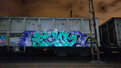 Cyan and Blue Stylewriting by DCK, Elmo and ALL CAPS COLLECTIVE. This Graffiti is located in Hungary and was created in 2020. This Graffiti can be described as Stylewriting, Trains, Freights and Atmosphere.