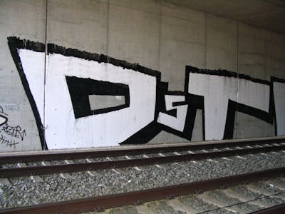 Black and White Stylewriting by urine and OST. This Graffiti is located in Bitterfeld, Germany and was created in 2006. This Graffiti can be described as Stylewriting, Roll Up and Line Bombing.
