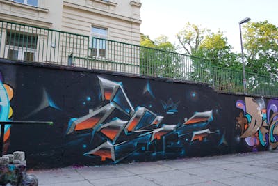 Grey and Orange Stylewriting by Kan, TMF and Posa. This Graffiti is located in Weimar, Germany and was created in 2021. This Graffiti can be described as Stylewriting, 3D and Wall of Fame.
