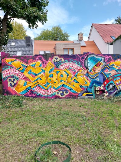 Colorful and Orange and Violet Stylewriting by Shew, the Buddys and Büro21. This Graffiti is located in Strausberg, Germany and was created in 2023. This Graffiti can be described as Stylewriting and Characters.