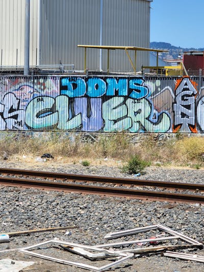 Cyan and Violet and Light Blue Stylewriting by Doms and Cluer. This Graffiti is located in United States and was created in 2022. This Graffiti can be described as Stylewriting and Line Bombing.