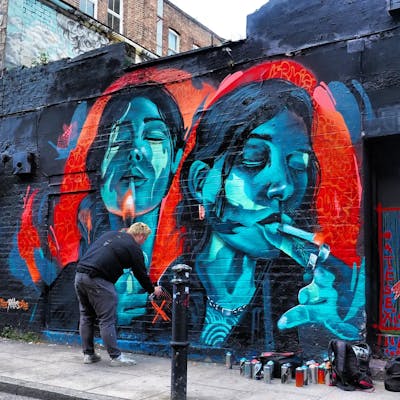 Cyan and Red Characters by REVES ONE and SIDOK. This Graffiti is located in United Kingdom and was created in 2024. This Graffiti can be described as Characters, Streetart and Murals.
