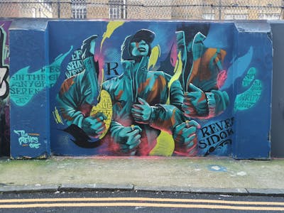 Cyan and Colorful Characters by REVES ONE. This Graffiti is located in United Kingdom and was created in 2024. This Graffiti can be described as Characters and Streetart.