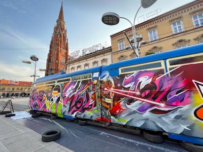 Colorful Trains by SNUZ and SEC. This Graffiti is located in OSIJEK, Croatia and was created in 2023. This Graffiti can be described as Trains, Stylewriting and Characters.