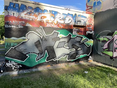 Grey and Green Stylewriting by ORES24. This Graffiti is located in Rostock, Germany and was created in 2021.