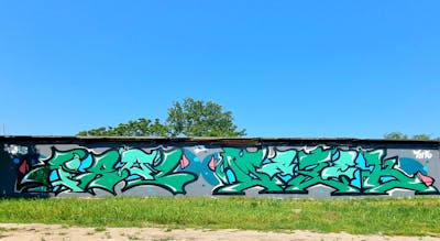 Green Stylewriting by IBM5, Masek, Tirol and 7US. This Graffiti is located in Sun city, Hungary and was created in 2023.