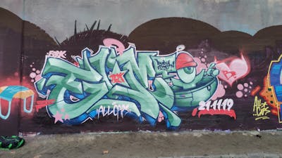 Cyan and Colorful Stylewriting by DCK, Elmo and ALL CAPS COLLECTIVE. This Graffiti is located in Hungary and was created in 2021. This Graffiti can be described as Stylewriting, Characters and Wall of Fame.