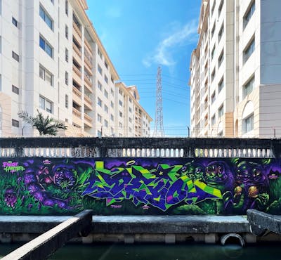 Violet and Light Green and Blue Stylewriting by DEIO. This Graffiti is located in Bangkok, Thailand and was created in 2023. This Graffiti can be described as Stylewriting, Characters and Atmosphere.