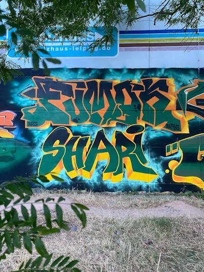 Green and Orange Stylewriting by Fumok and Shari. This Graffiti is located in Leipzig, Germany and was created in 2022. This Graffiti can be described as Stylewriting and Wall of Fame.