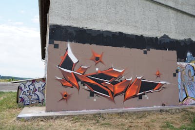 Orange Stylewriting by TMF and Kan. This Graffiti is located in Weimar, Germany and was created in 2021. This Graffiti can be described as Stylewriting and Futuristic.